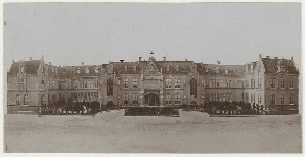 Historical photo of the former Mariastichting hospital: a wide nineteenth-century building with pointed gables and a cross on the roof.