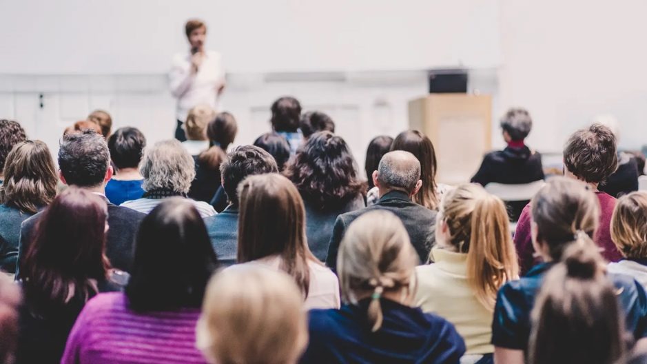 Toehoorders in een zaal tijdens een ledenvergadering.