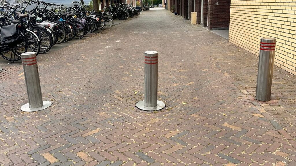 Uitgeschoven blokkadepalen in de doorgang naar het buitenterrein.
