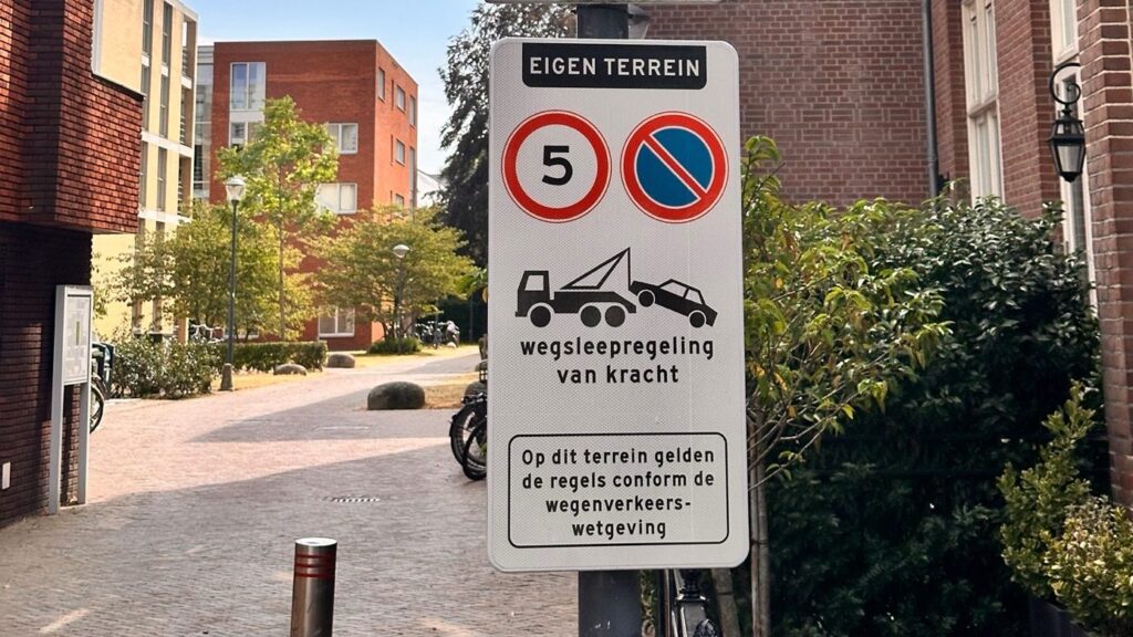 Bord 'eigen terrein' met maximumsnelheid 5 km per uur en wegsleepregeling.