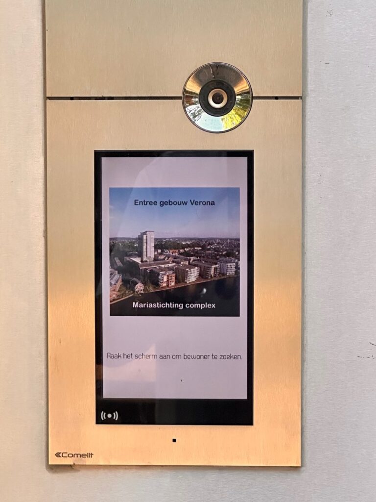 Videofoon-entreepaneel met camera en touchscreen bij de ingang van gebouw Verona.